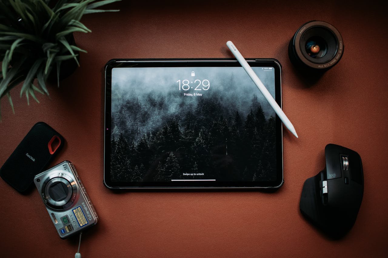 Minimalist flat lay of tablet and gadgets on a desk, showcasing modern technology.