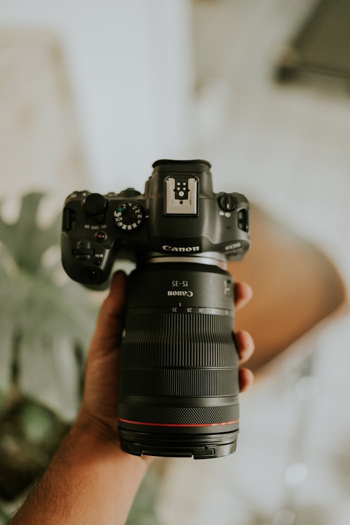 Close-up of a DSLR camera being held, focusing on the lens and grip.